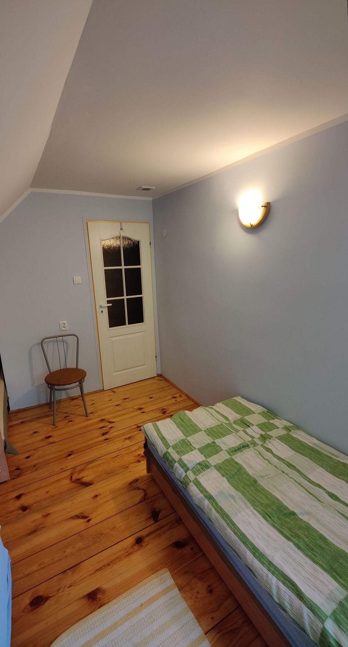 Widok na drzwi i łóżko w pokoju 02